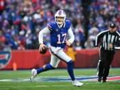 Buffalo Bills quarterback Josh Allen runs while holding a football.