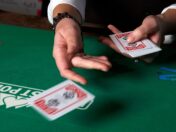 A poker dealer tosses a card.