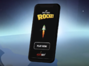 A rendered image of a mobile phone displaying the DraftKings Rocket frontscreen, super imposed over the planet Earth.
